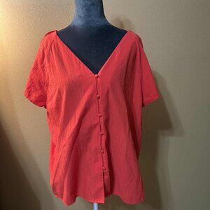 Ladies red short sleeve blouse with fabric button detail.